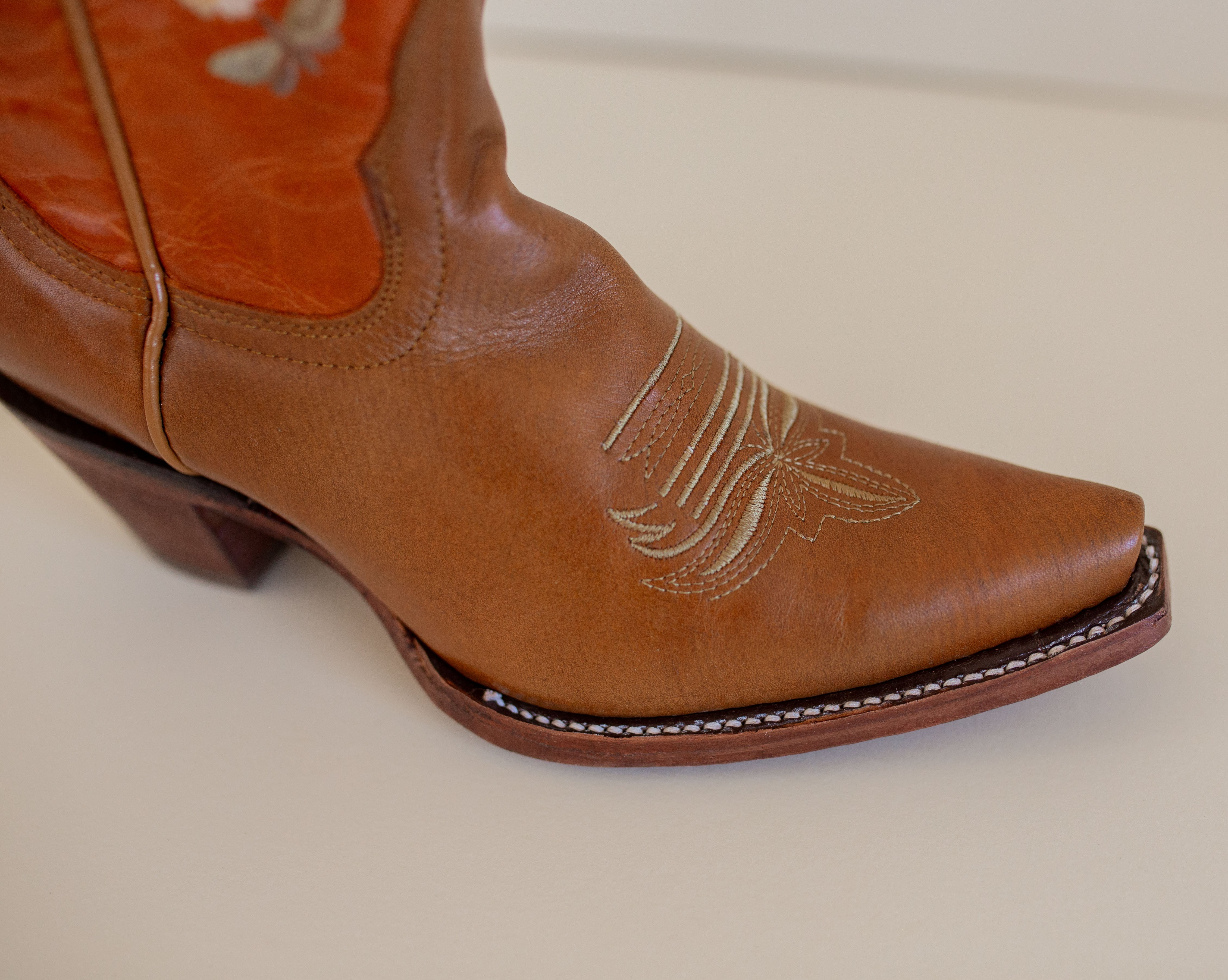 Marci Western Boot Embroidered Floral Pattern on tall Part, Reddish brown Top color, and a brown toe/foot part with a pointed toe