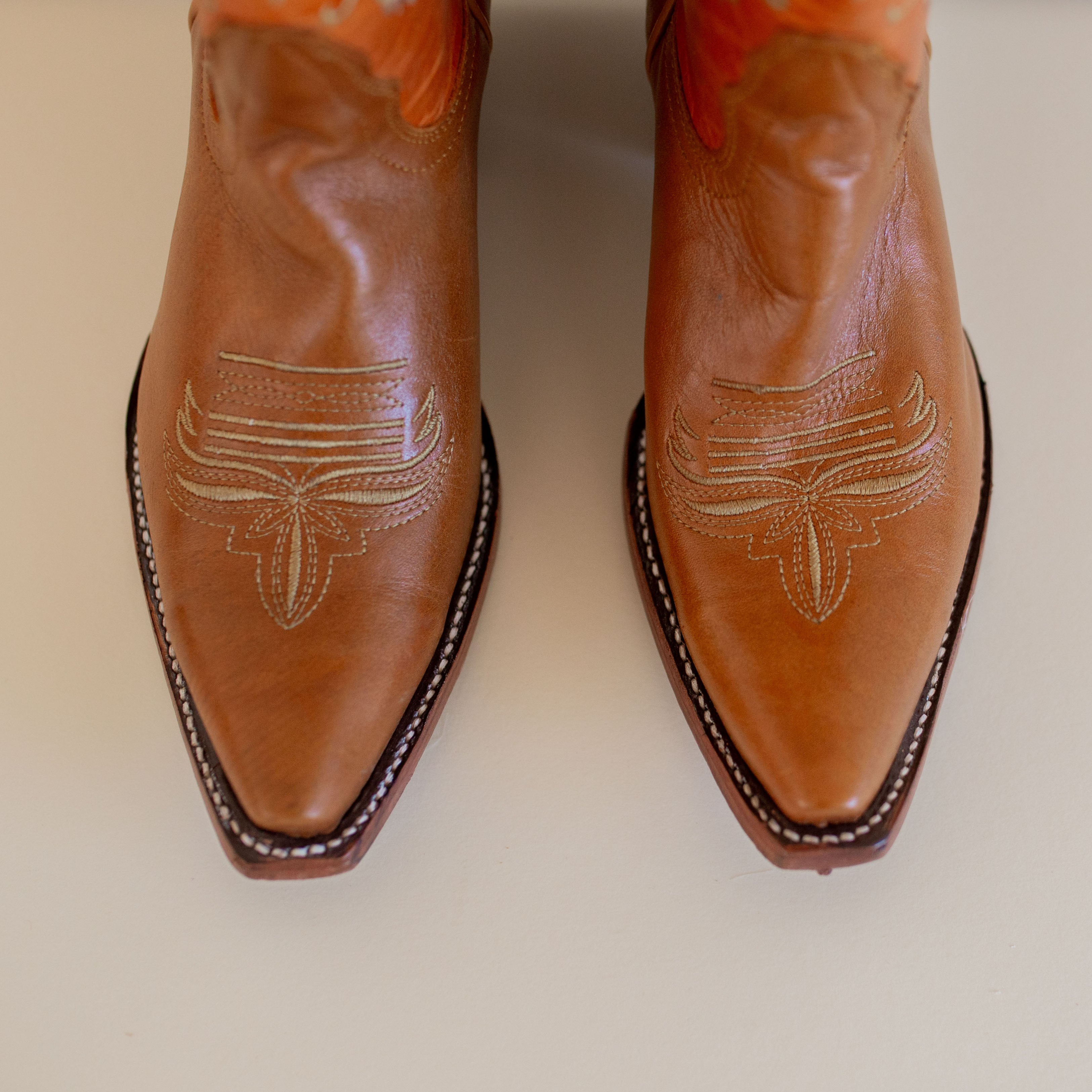 Marci Western Boot Embroidered Floral Pattern on tall Part, Reddish brown Top color, and a brown toe/foot part with a pointed toe