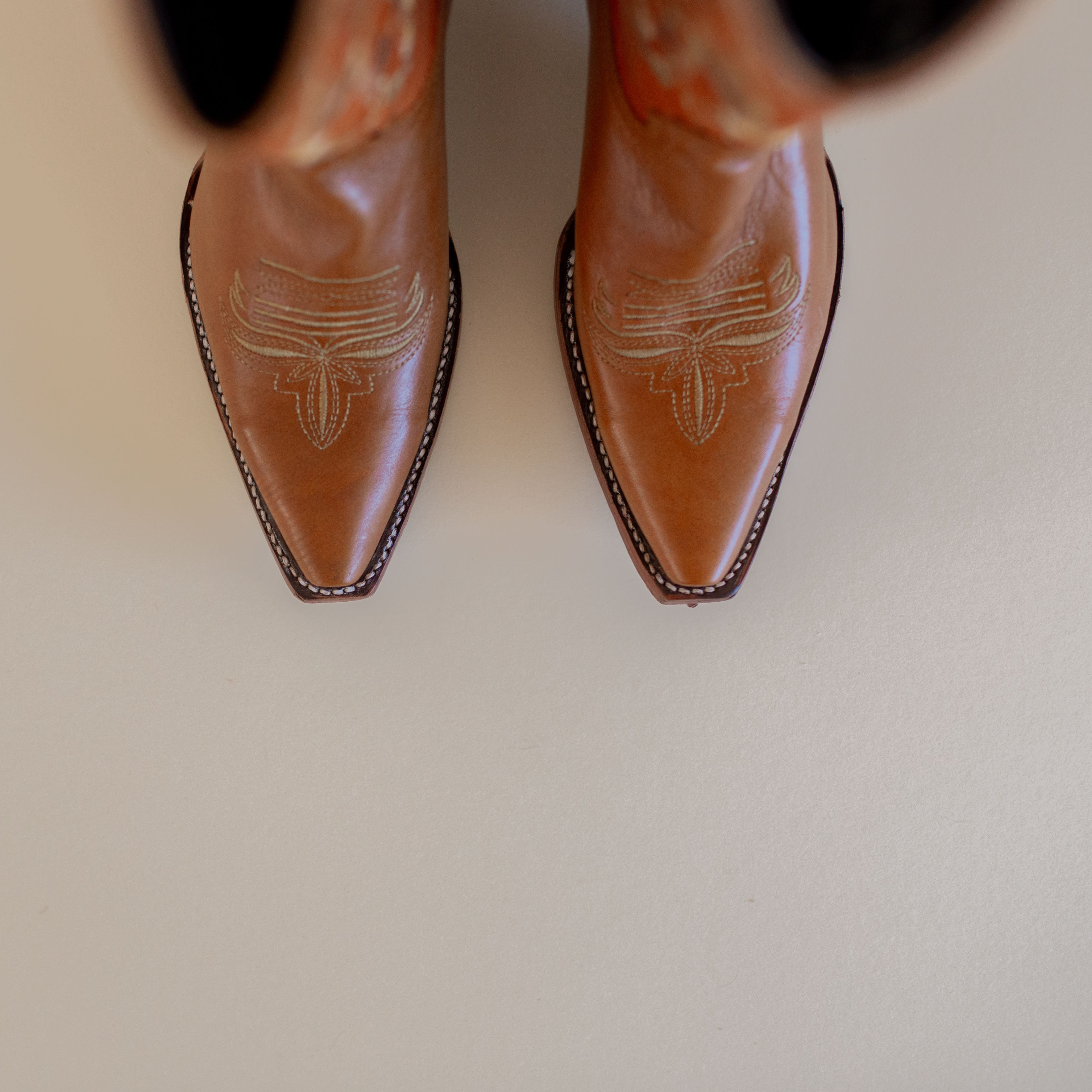 Marci Western Boot Embroidered Floral Pattern on tall Part, Reddish brown Top color, and a brown toe/foot part with a pointed toe